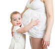 Photo: Little boy hugging pregnant mother's belly and looking directly Little boy hugging pregnant mother's belly and looking directly