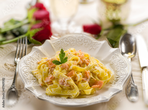 Photo: tagliatelle with salmon and cream sauce on luxury table tagliatelle with salmon and cream sauce on luxury table