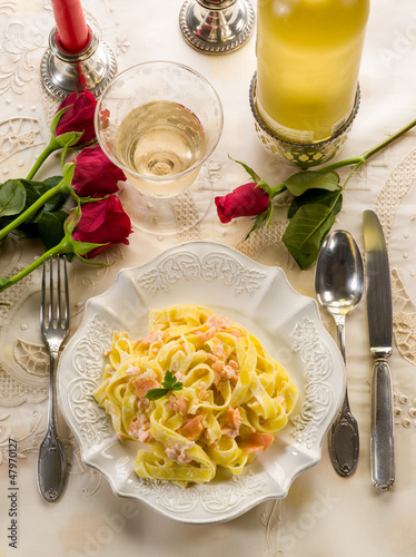 Photo: tagliatelle with salmon and cream sauce on luxury table tagliatelle with salmon and cream sauce on luxury table