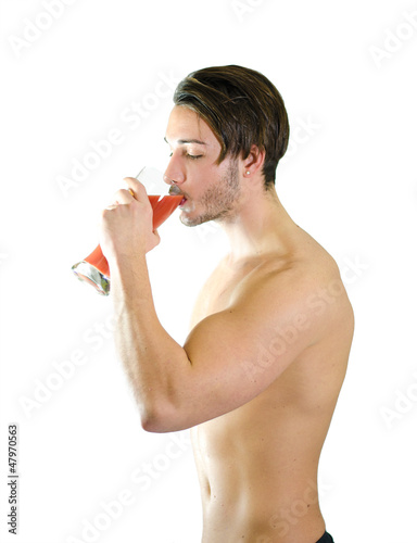 Photo: No more beer! Shirtless young man drinking fruit juice No more beer! Shirtless young man drinking fruit juice