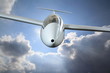 White sailplane flying through rain clouds