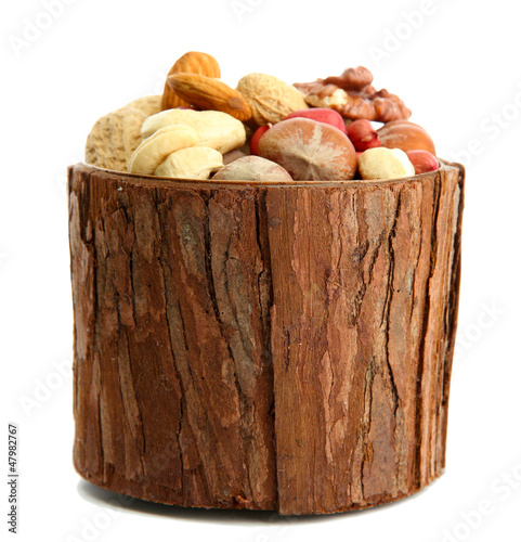 Photo: assortment of tasty nuts in wooden vase, isolated on white assortment of tasty nuts in wooden vase, isolated on white