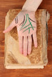 Chiromancy.Color contours on palm, on wooden background