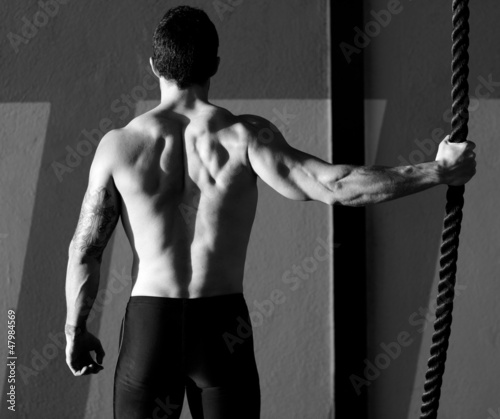 Photo: Crossfit gym man holding hand a climbing rope Crossfit gym man holding hand a climbing rope