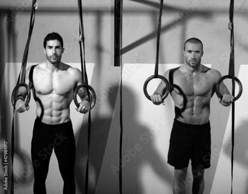 Photo: Crossfit dip ring two men workout at gym Crossfit dip ring two men workout at gym
