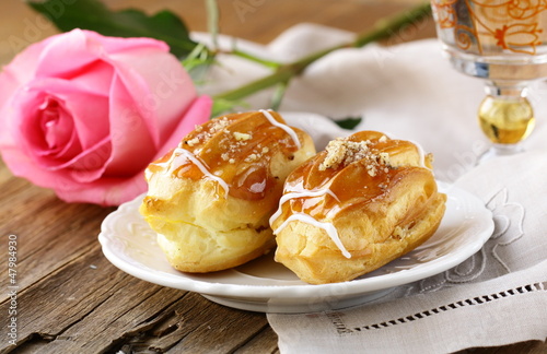 Photo: cakes eclair profiteroles on a plate - a dessert for two cakes eclair profiteroles on a plate - a dessert for two