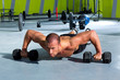 Foto: Gym man push-up strength pushup exercise with dumbbell Gym man push-up strength pushup exercise with dumbbell