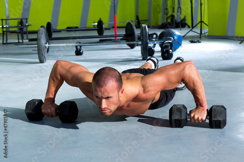 Photo: Gym man push-up strength pushup exercise with dumbbell Gym man push-up strength pushup exercise with dumbbell