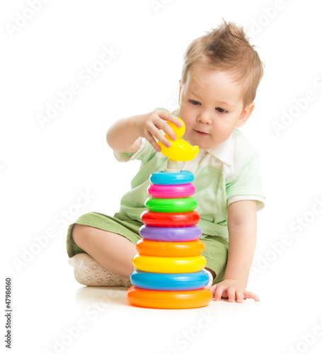 Photo: Cute boy playing colorful tower isolated on white Cute boy playing colorful tower isolated on white