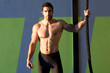 Crossfit gym man holding hand a climbing rope