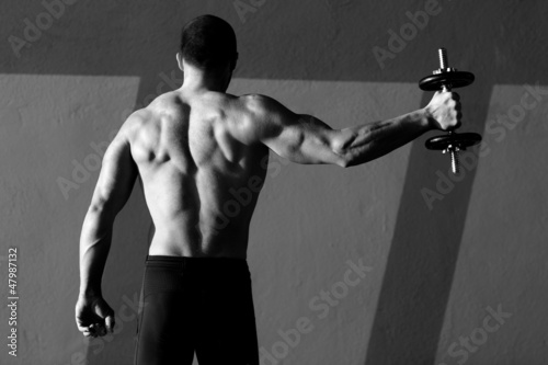 Photo: Dumbbell man rear view with back muscles Dumbbell man rear view with back muscles