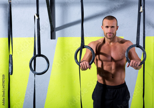 Photo: Crossfit dip ring man relaxed after workout at gym Crossfit dip ring man relaxed after workout at gym