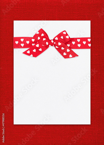 Photo: red bow on paper sheet red bow on paper sheet