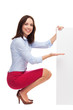Businesswoman crouching by blank board
