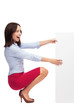 Businesswoman crouching by blank board