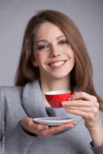 Photo: Cute girl holding a cup of coffee Cute girl holding a cup of coffee