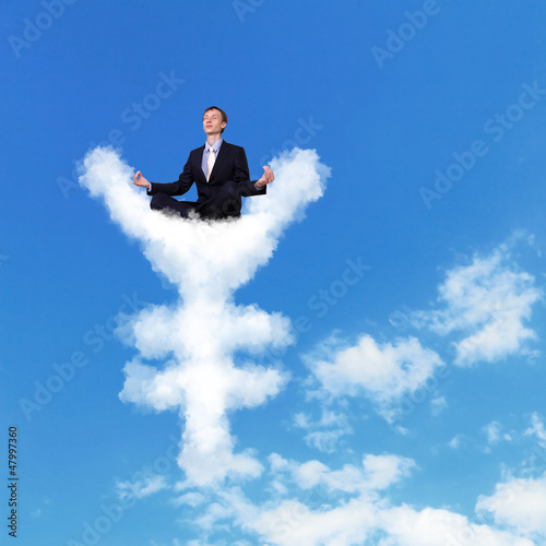 Photo: Businessman meditating sitting on the cloud Businessman meditating sitting on the cloud