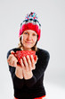 Smiling woman in knitted hat holding cup