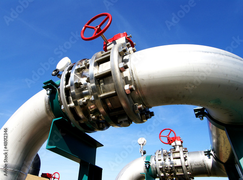 Photo: Industrial zone, Steel pipelines and valves against blue sky Industrial zone, Steel pipelines and valves against blue sky