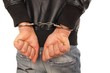 Mann in Handschellen hinter Rücken mit geballten Fäusten
