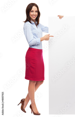 Photo: Beautiful woman pointing at blank board Beautiful woman pointing at blank board