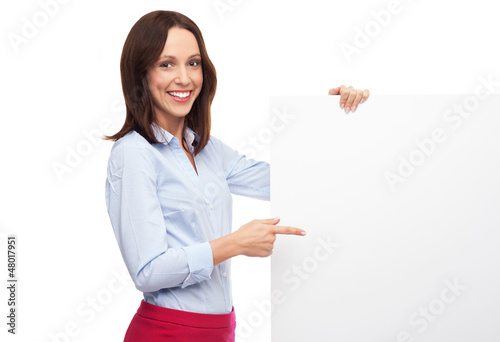 Photo: Beautiful woman pointing at blank board Beautiful woman pointing at blank board
