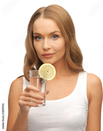 Photo: woman with lemon slice on glass of water woman with lemon slice on glass of water