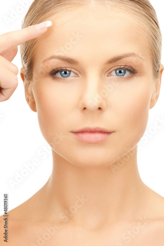 Photo: beautiful woman pointing to forehead beautiful woman pointing to forehead
