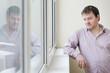 Courageous middle age man looking at snow into the window