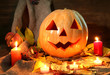 halloween pumpkin and autumn leaves, on wooden background