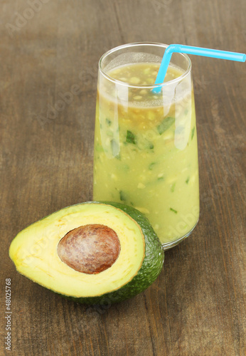 Photo: Useful fresh avocado and half avocado on wooden table close-up Useful fresh avocado and half avocado on wooden table close-up