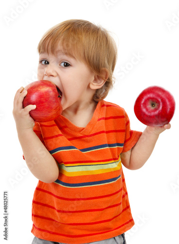 Photo: cute little boy eating apples, isolated on white cute little boy eating apples, isolated on white