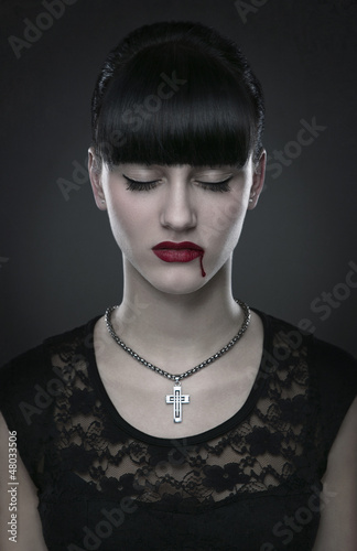 Photo: Beautiful gothic vampire woman portrait over dark background Beautiful gothic vampire woman portrait over dark background