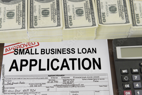 Photo: Approved small business loan application form and money Approved small business loan application form and money