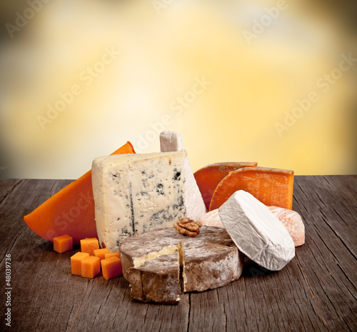 Photo: Delicious fresh french cheeses served on wooden table Delicious fresh french cheeses served on wooden table