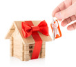 Hand with keys and wooden house