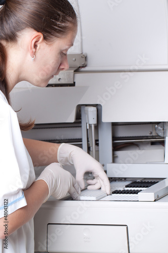 Photo: Woman loading samples in biochemical analyzer Woman loading samples in biochemical analyzer