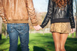 Hand in hand romantic young couple walking outdoors.