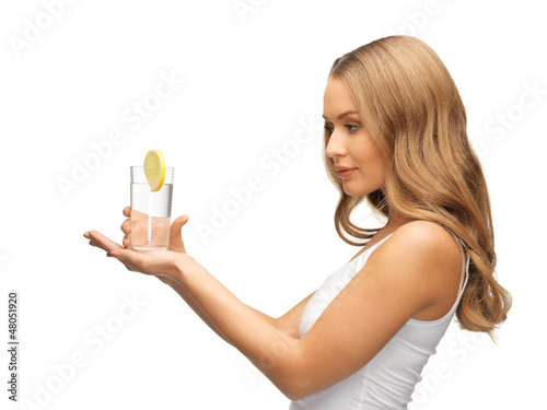 Photo: woman with lemon slice on glass of water woman with lemon slice on glass of water