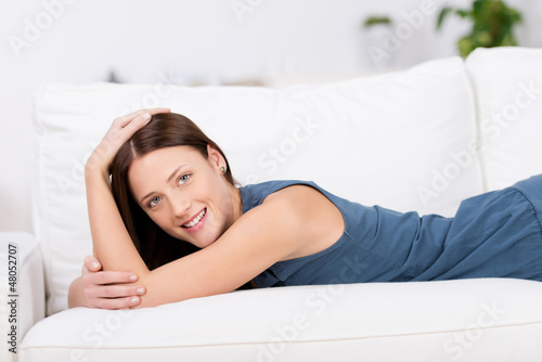 Photo: lächelnde frau liegt auf dem sofa lächelnde frau liegt auf dem sofa