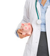 Photo: Closeup on medical doctor holding piggy bank Closeup on medical doctor holding piggy bank
