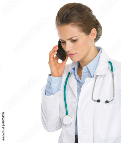 Photo: Concerned medical doctor woman speaking mobile phone Concerned medical doctor woman speaking mobile phone