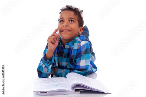 Photo: Little african boy lying down on the floor and reading book Little african boy lying down on the floor and reading book