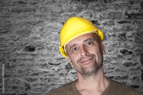 Photo: Friendly smiling worker with helmet Friendly smiling worker with helmet