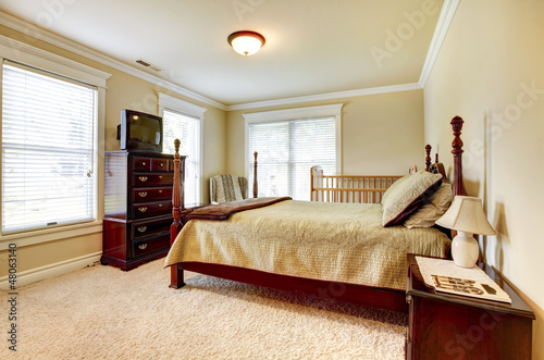 Photo: Large bright bedroom with wood furniture and beige tones. Large bright bedroom with wood furniture and beige tones.