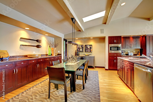 Photo: Luxury modern dining room with mahogany kitchen. Luxury modern dining room with mahogany kitchen.