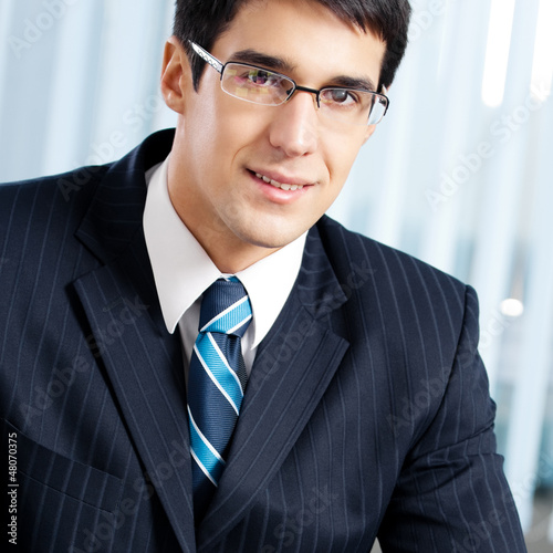 Photo: Happy smiling businessman at office Happy smiling businessman at office
