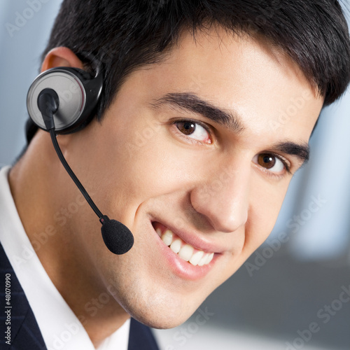 Photo: Support phone operator in headset at workplace Support phone operator in headset at workplace