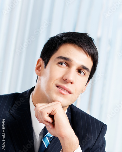 Photo: Portrait of thinkihg businessman at office Portrait of thinkihg businessman at office