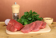 Raw beef meat with spices on wooden table on brown background
